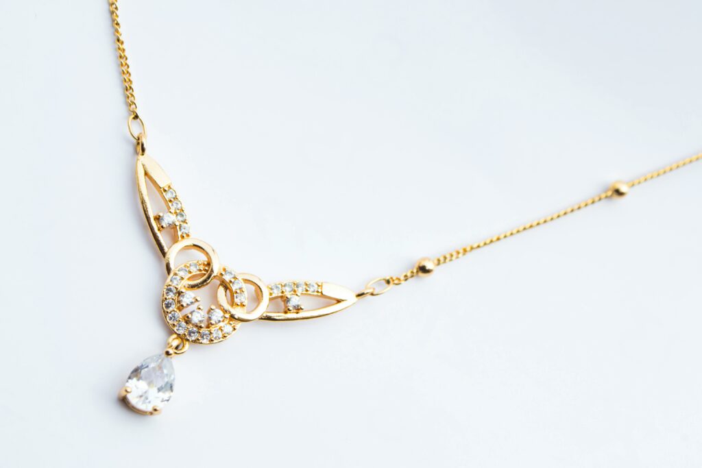 Luxury gold necklace featuring diamond accents on a white background.